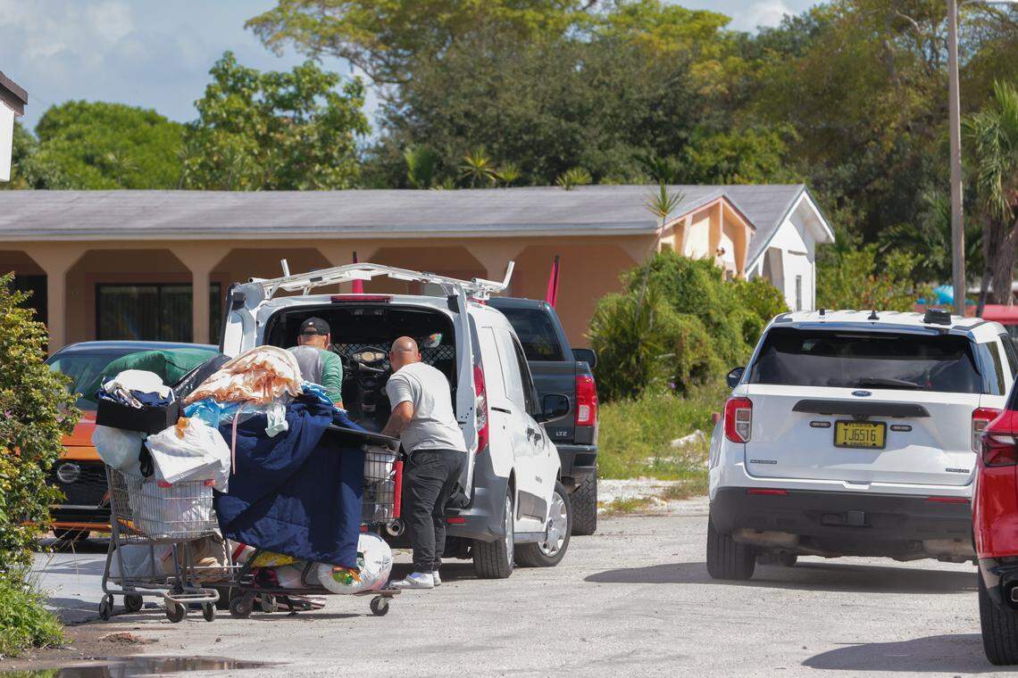 Residents of the Li'l Abner Mobile Home Park at 11239 NW 4th Terrace collect their belongings as a patrol vehicle from the Miami-Dade Sheriff's Office drives around the mobile home community in Sweetwater, Florida, Monday, October 20, 2025.