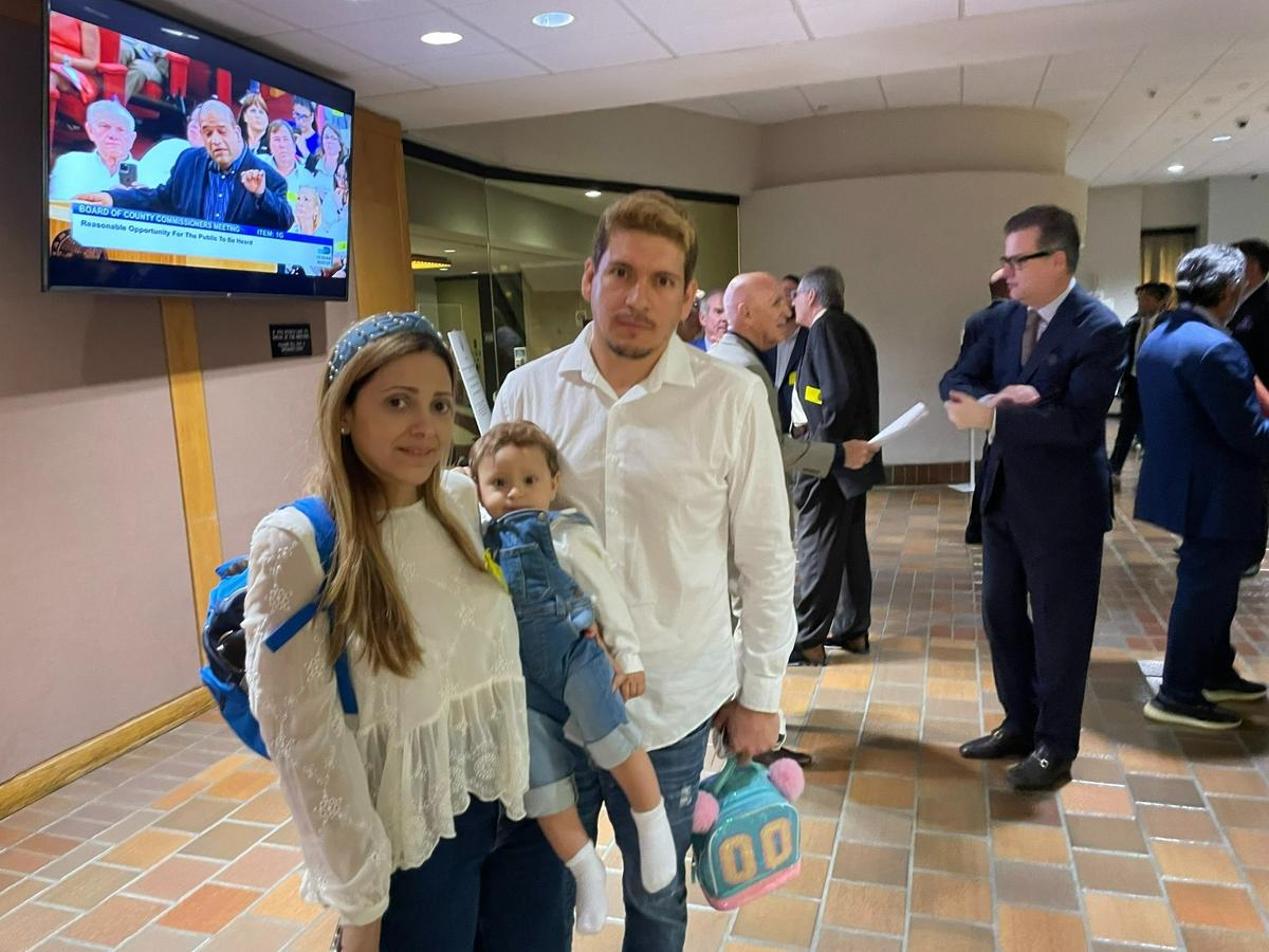 Danielle Ramirez and Ranghiv Acurero, with their one-year-old son, Oliver, in the lobby of the Miami-Dade County Commission chambers on Tuesday, March 7, 2023. The couple live near a county-owned trash incinerator in Doral, where a fire caused harmful smoke to blow through residential neighborhoods.
