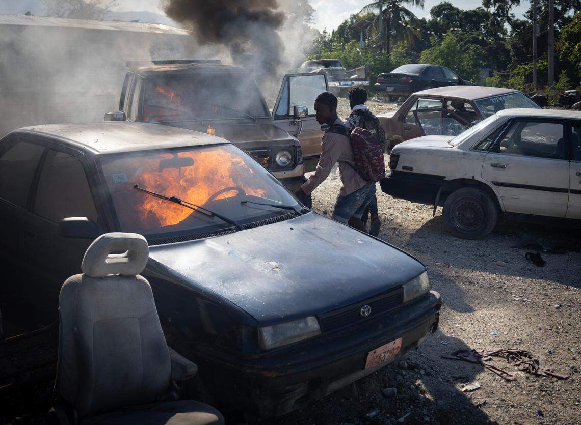 Gang members set cars on fire during a raid in a neighborhood of Port-au-Prince on Dec. 7, 2024.