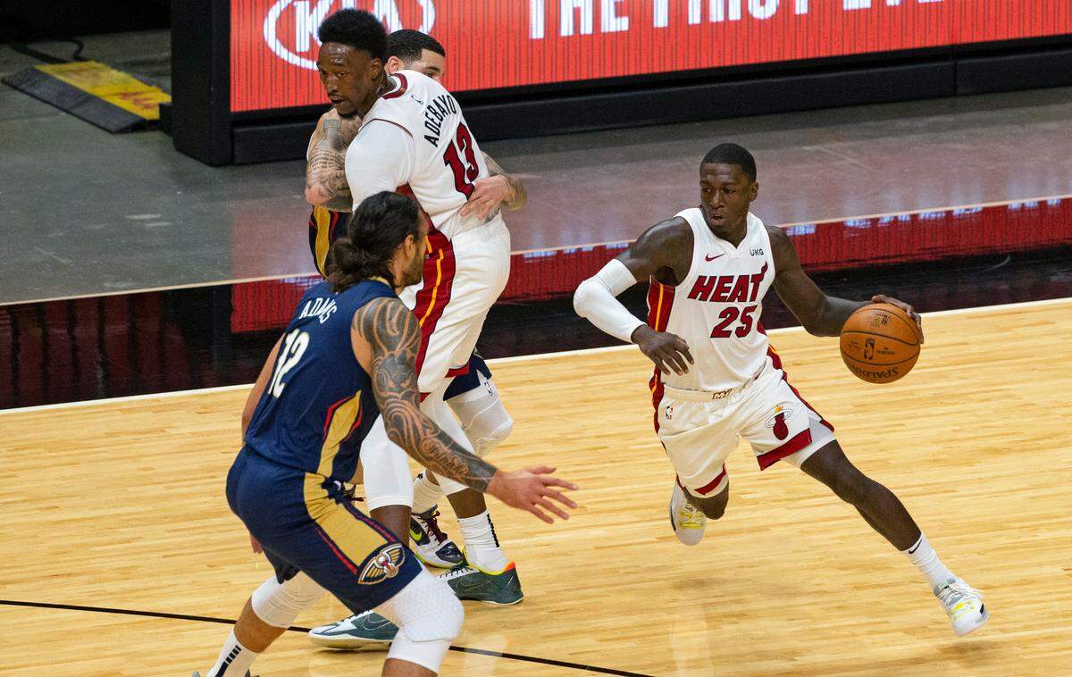 New Orleans Pelicans center Steven Adams (12) defends as Miami Heat guard Kendrick Nunn (25) drives to the basket around a screen by teammate Bam Adebayo (13) in the first quarter of an NBA basketball preseason game at AmericanAirlines Arena on Monday, Dec. 14, 2020.