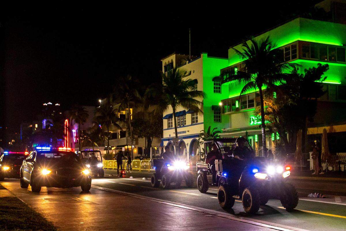 Miami Beach Police ride their all-terrain vehicles in the street as they clear Ocean Drive because the City of Miami Beach imposed a curfew at midnight to curb violence during Spring Break in Miami Beach, Florida, on Thursday, March 24, 2022.