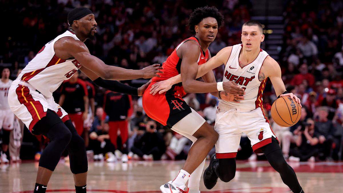 Miami Heat guard Tyler Herro (14) handles the ball against Houston Rockets guard Amen Thompson (1) during the fourth quarter at Toyota Center.