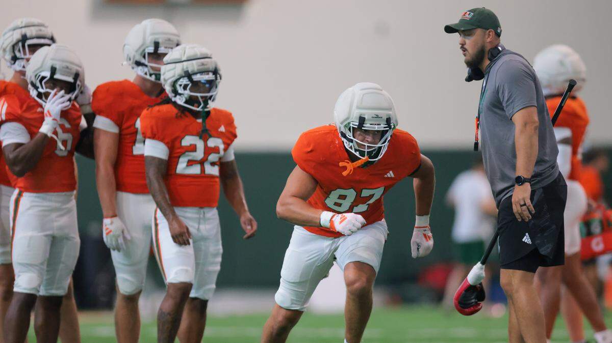 Miami Hurricanes tight end Alex Bauman (87) works with tight ends coach Cody Woodiel during football practice at the Carol Soffer Indoor Practice Facility at the University of Miami in Coral Gables, Florida, on Thursday, Aug. 7, 2025.