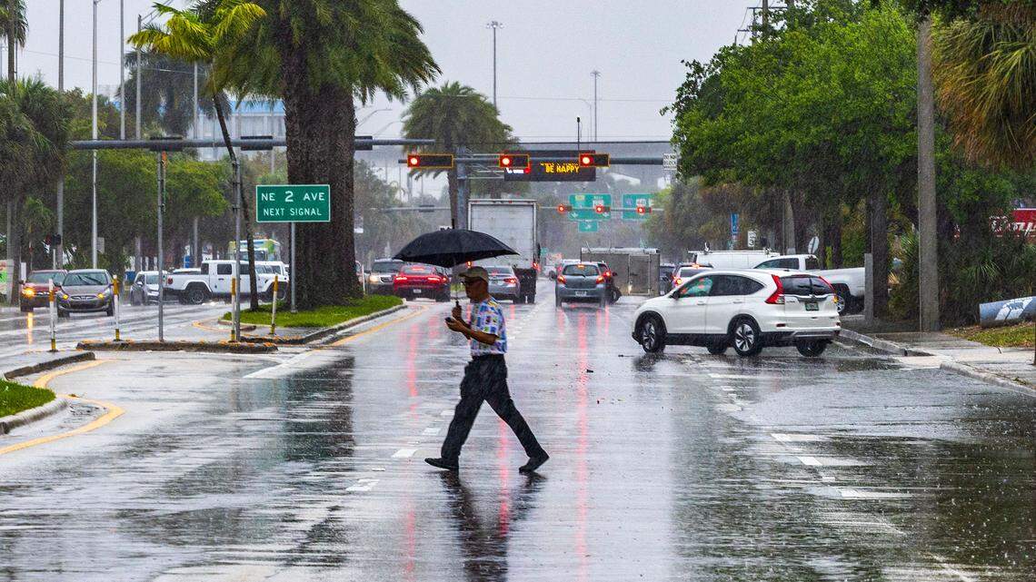 A man crosses 163rd Street in North Miami under heavy rain as a severe weather alert was issued by the National Weather Service on March 22, 2024.
