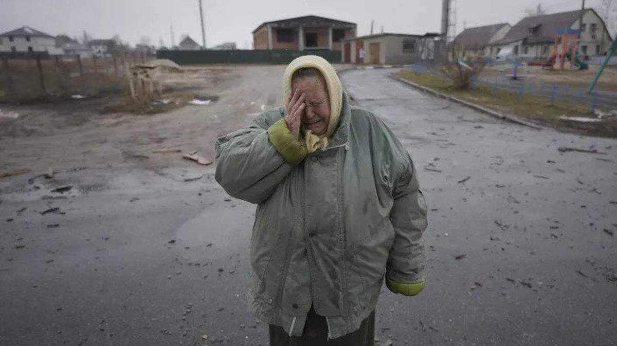 A woman cries outside houses damaged by what residents said was a Russian airstrike in Gorenka, Ukraine.