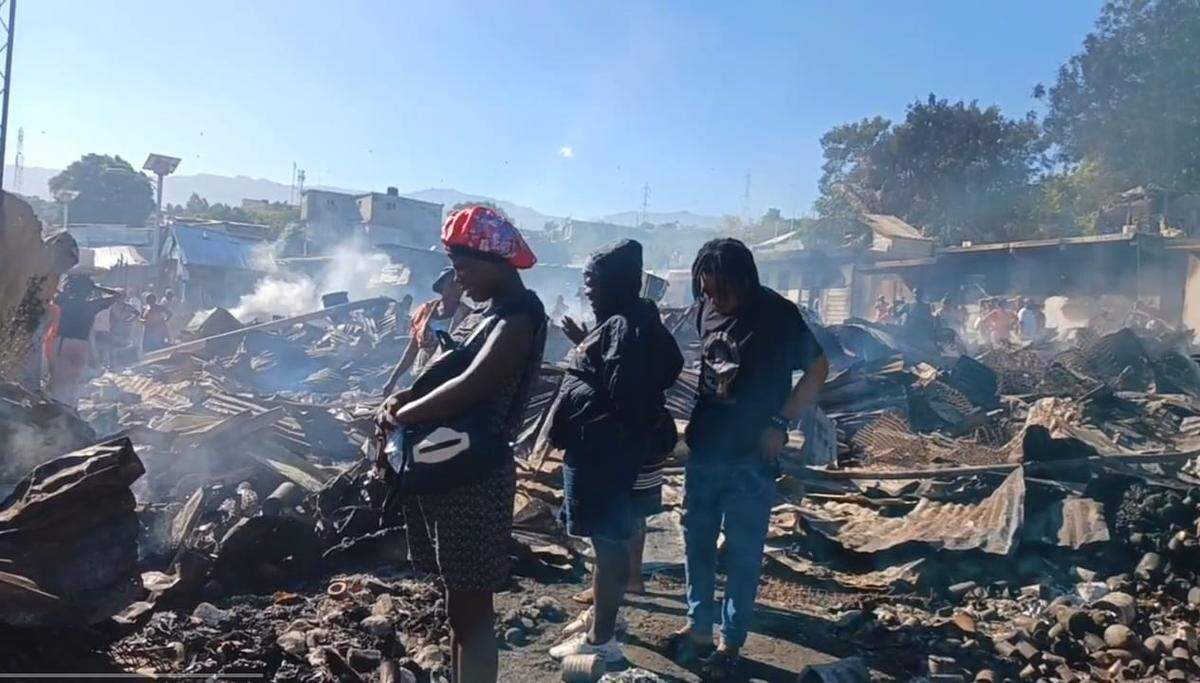 Merchants in Port-au-Prince’s Delmas 33 neighborhood on December 11, 2025 survey the burnt remnants of the Dumornay Market after fire swept through the day before and burned everything.