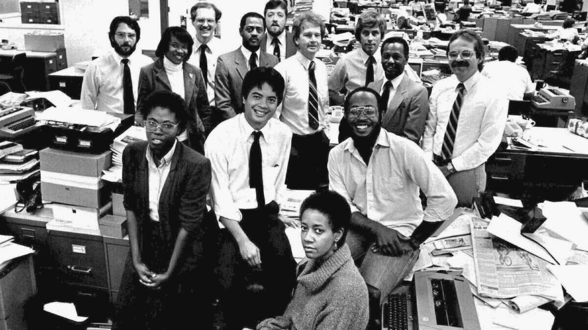 Photo circa December, 1983, The Miami Herald newsroom: The Miami Herald’s week-long “Isolation of Black Miami” series concluded Dec. 3, 1983. As part of the paper’s investigation, Two Herald reporters — one white and one black — found apparent racial discrimination at 24 of 45 Dade apartment complexes from North Miami to Coral Gables. In most cases, rental agents told the black reporter that no apartments were available for rent. The white reporter, arriving minutes later, was welcomed to vacant apartments, ready for occupancy. In this photo in The Herald newsroom at 1 Herald Plaza, Itabari Njeri is seated at the typewriter. Behind her are Ellyn Ferguson, Robert (Bob) Lowe and Michel du Cille; in the next row, from left, are Bea Hines, Michael Cottman, Jim Savage, Larry Bivins and Richard Morin; last row from left are Mark Silva, David Marcus, Paul Shannon and Carl Hiaasen.