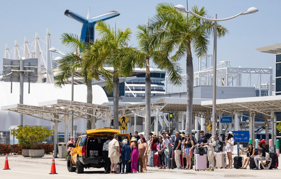 A group of travelers wait for shuttles at PortMiami on Friday, April 12, 2024, in Miami, Fla.