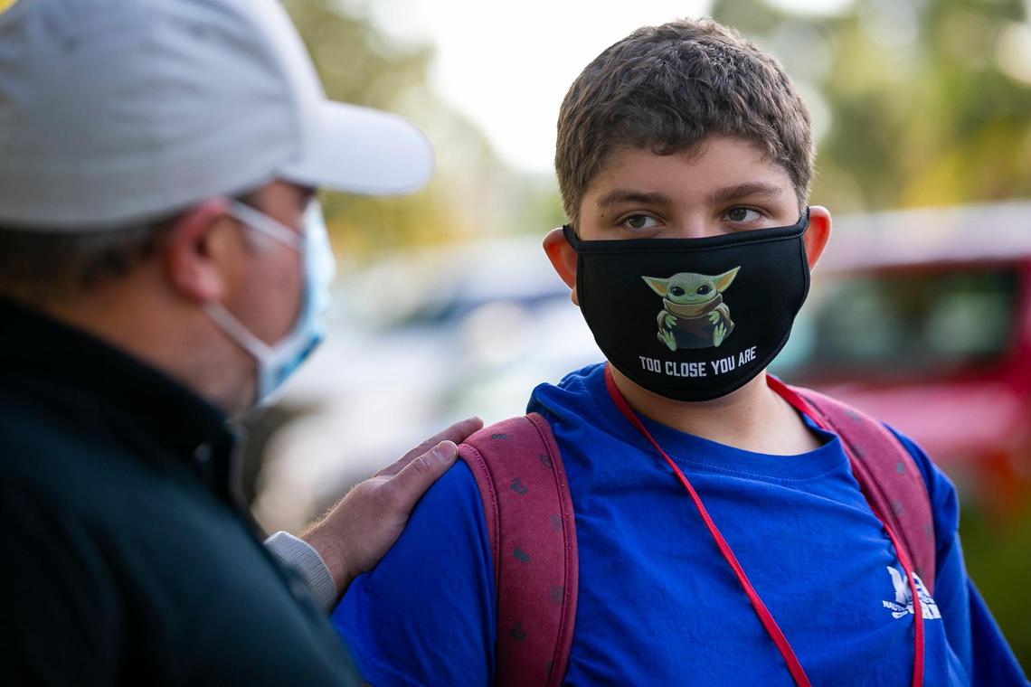 James Orlowsky, left, drops off his son, Noah Orlowsky, a seventh-grader at Miami Beach Nautilus Middle School, for in-person classes on Friday, Oct. 9, 2020.