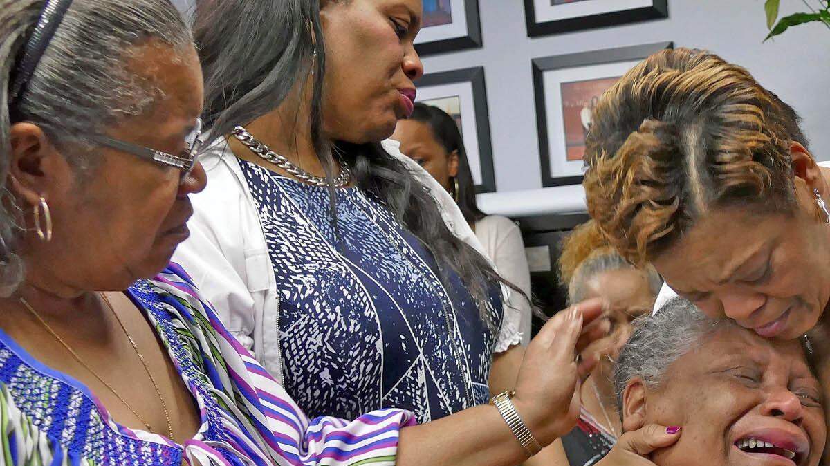 Willie Jean Coleman, is comforted by family members and friends after Willie Jean pleaded for help and information about who killed her husband Willie Warren at press conference at Miami Police Department on Tuesday March 17, 2015. 