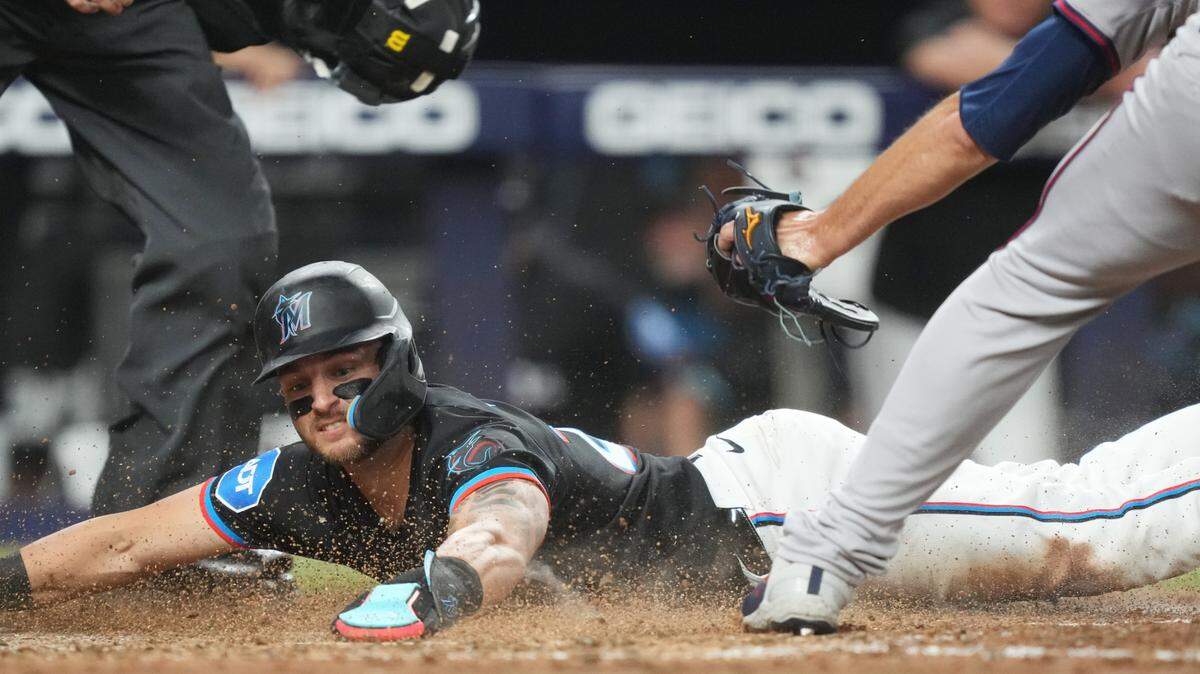 Sep 20, 2024; Miami, Florida, USA; Miami Marlins third baseman Connor Norby (24) scores on a wild pitch by Atlanta Braves pitcher Charlie Morton (50) in the fifth inning at loanDepot Park. Mandatory Credit: Jim Rassol-Imagn Images