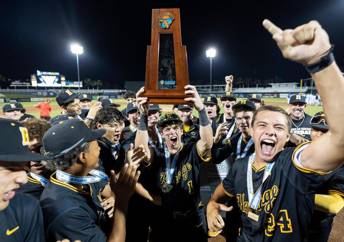 American Heritage Patriots’ Chris Levy (1) lifts the trophy after defeating the Mulberry Panthers in their Class 4A state baseball championship game at Hammond Stadium on Tuesday, May 20, 2025, in Fort Myers, Fla.