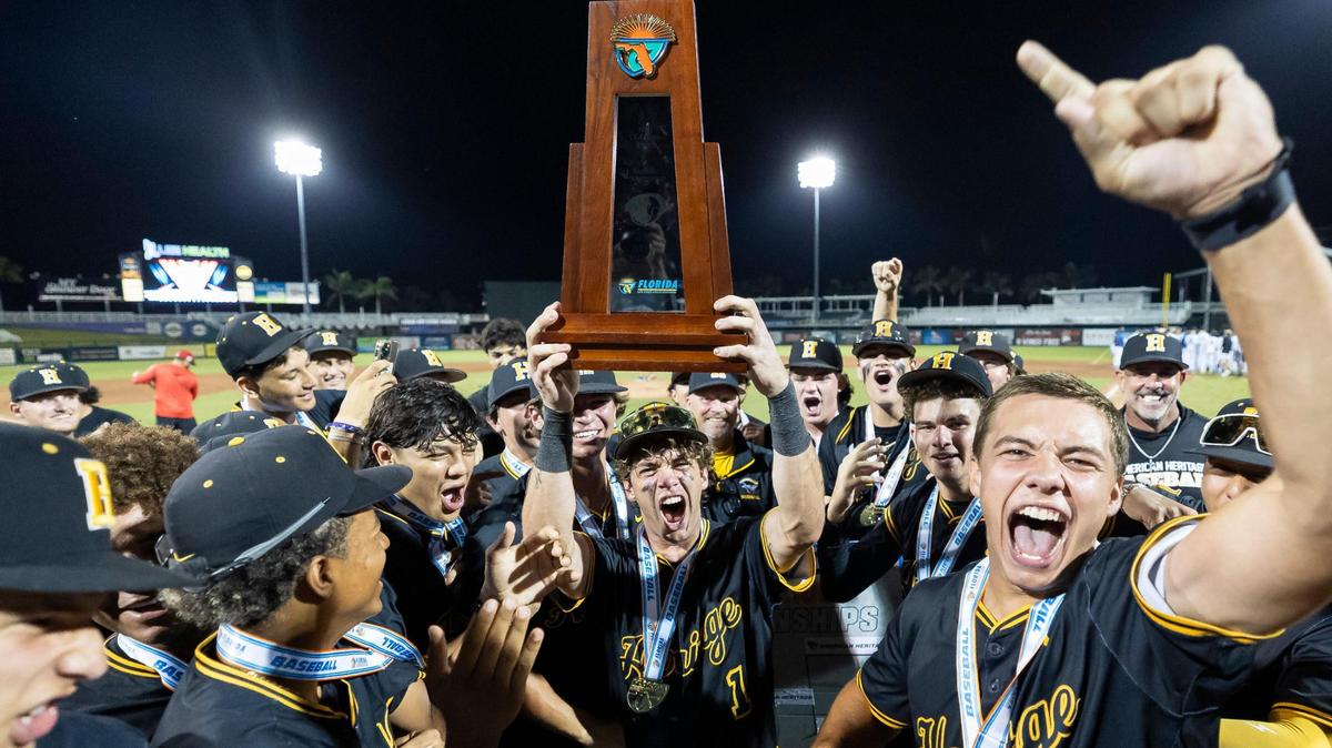 American Heritage Patriots Chris Levy (1) lifts the trophy after defeating the Mulberry Panthers in their Class 4A state baseball championship game at Hammond Stadium on Tuesday, May 20, 2025, in Fort Myers, Fla.