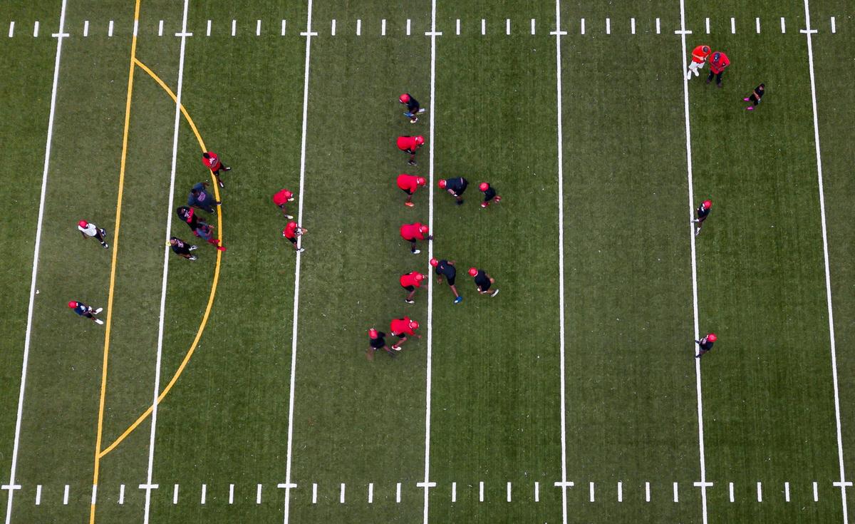 Miami Edison football players run drills during a preseason practice at their school’s field in Miami’s Little Haiti neighborhood on Tuesday, August 3, 2021.