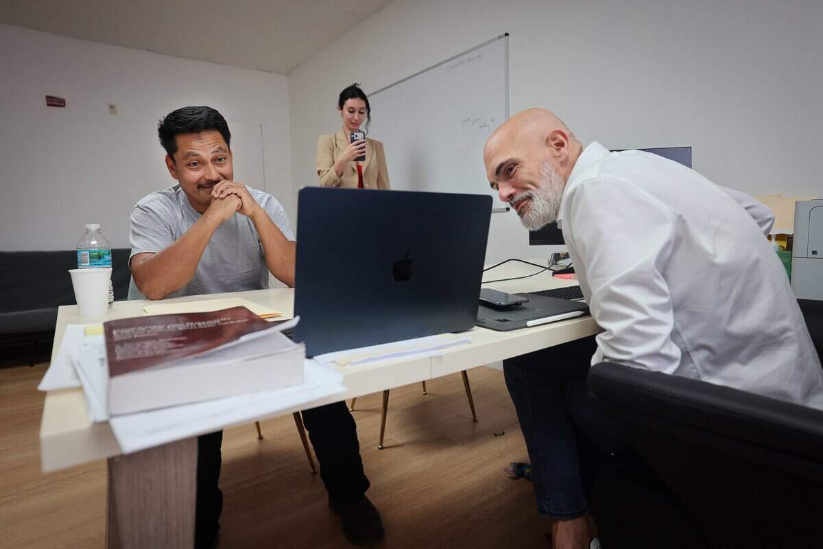 Rogelio, 39, left, a Guatemalan citizen who has lived in the United States since 2007 and is married to a U.S. citizen, that was released by ICE, speaks with his attorneys Victor Martinez, right, and another via video chat on Wednesday, February 18, 2026, and arrived at his lawyer's office in Miami, Florida.