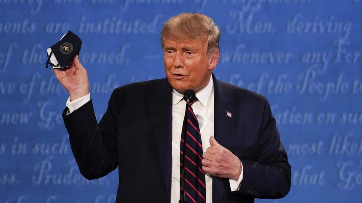President Trump holds up his face mask during the first presidential debate, three days before he tweeted that he and first lady Melania Trump tested positive for the coronavirus.