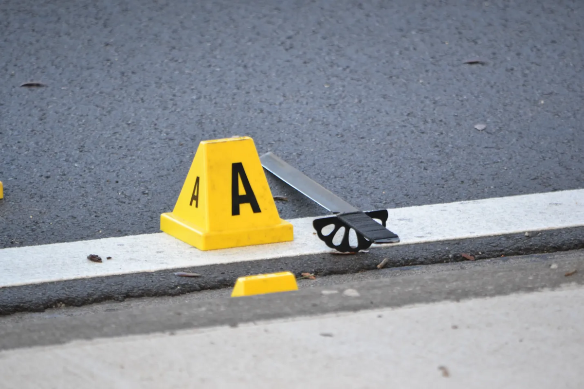 What appears to be a bladed weapon next to an evidence marker on the road near the village of Miami Shores. Police were investigating a crime scene where an officer allegedly shot someone on Sunday, June 21, 2026.