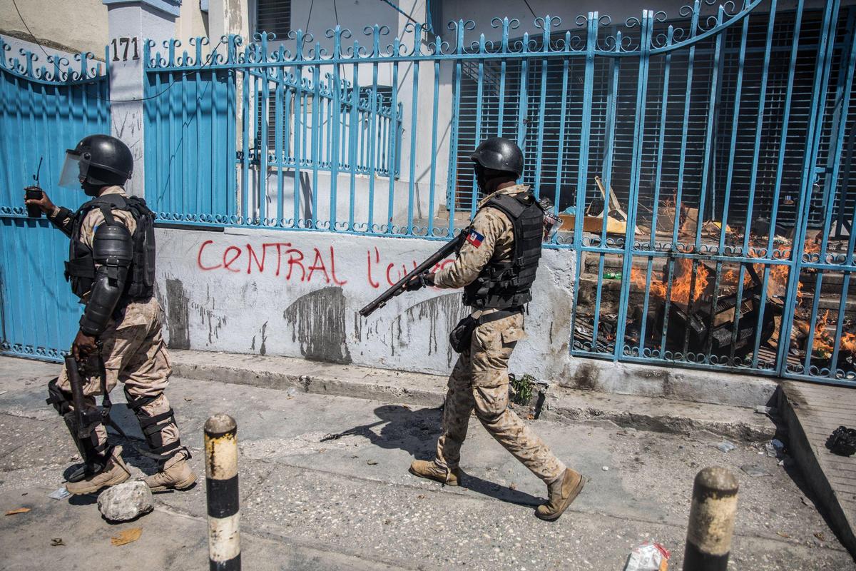 The police secure the area in front of the office of immigration and emigration after protesters tried to burn it during a demonstration demanding the resignation of President Jovenel Moise in the Haitian capital in Port-au-Prince on October 28, 2019.