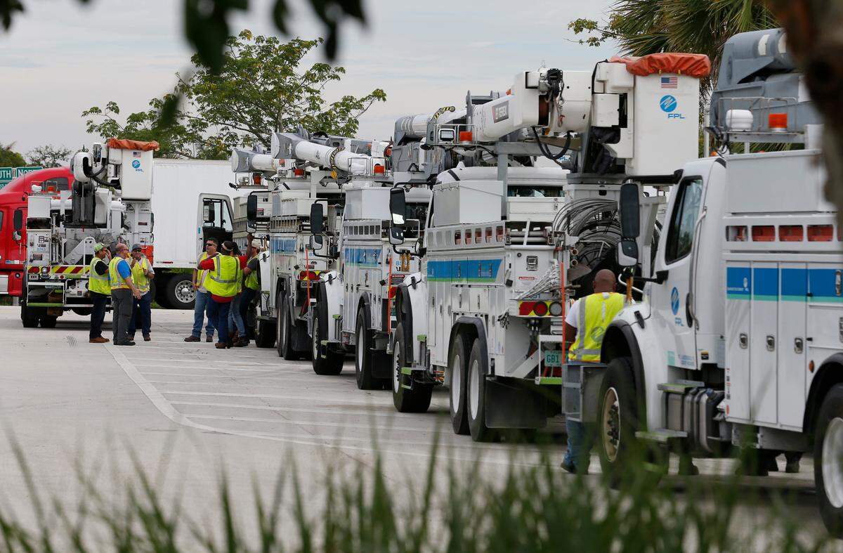 Florida Power & Light Company staff and contractors prepare bucket trucks and equipment before they leave for Walterboro, South Carolina from the West Palm Beach Service Plaza on Florida’s Turnpike in Lake Worth.