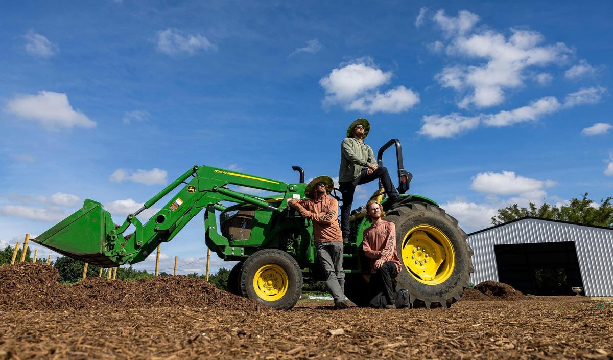 Chefs Joe Mizzoni, Jeremy Ford and Austin Anderson at Ford’s Farm in Redland on the farm’s tractor.