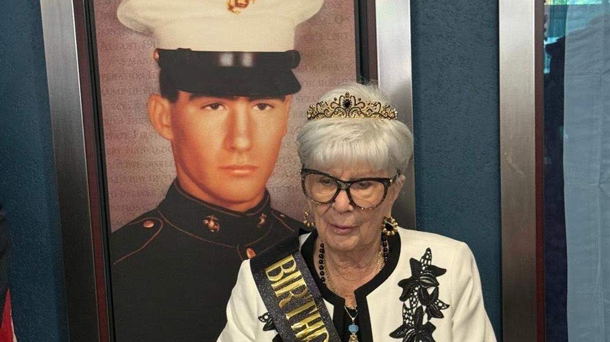 Georgie Carter Krell is honored at the Bruce W. Carter VA Medical Center in Miami on her 94th birthday on Friday, Aug. 25, 2025. A portrait of her son, Pfc. Bruce Wayne Carter, who was killed in Vietnam in August of 1969, is behind her. The medical center is named after him.