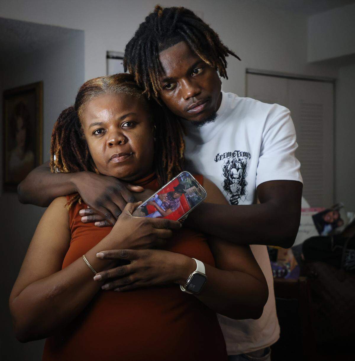 Guirlene Dorelus, left, holds a picture of Rodrigue Dor her late brother, while being reunited with her nephew Rodrigue Dor Jr., right, who arrived from Switzerland for his father' funeral on Wednesday, September 17, 2025, in Miami, Florida.