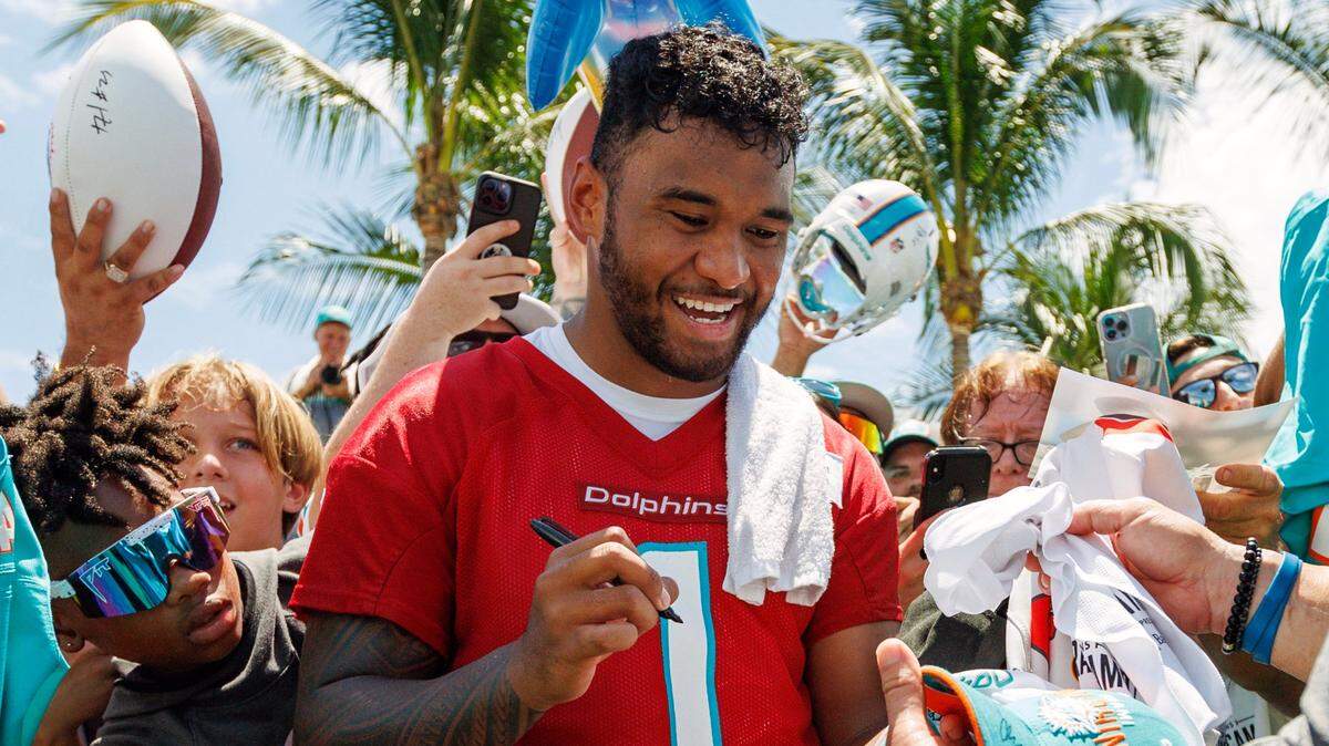 Miami Dolphins quarterback Tua Tagovailoa (1) sign autographs for fans after NFL football training camp at Baptist Health Training Complex in Hard Rock Stadium on Sunday, July 30, 2023 in Miami Gardens, Florida.