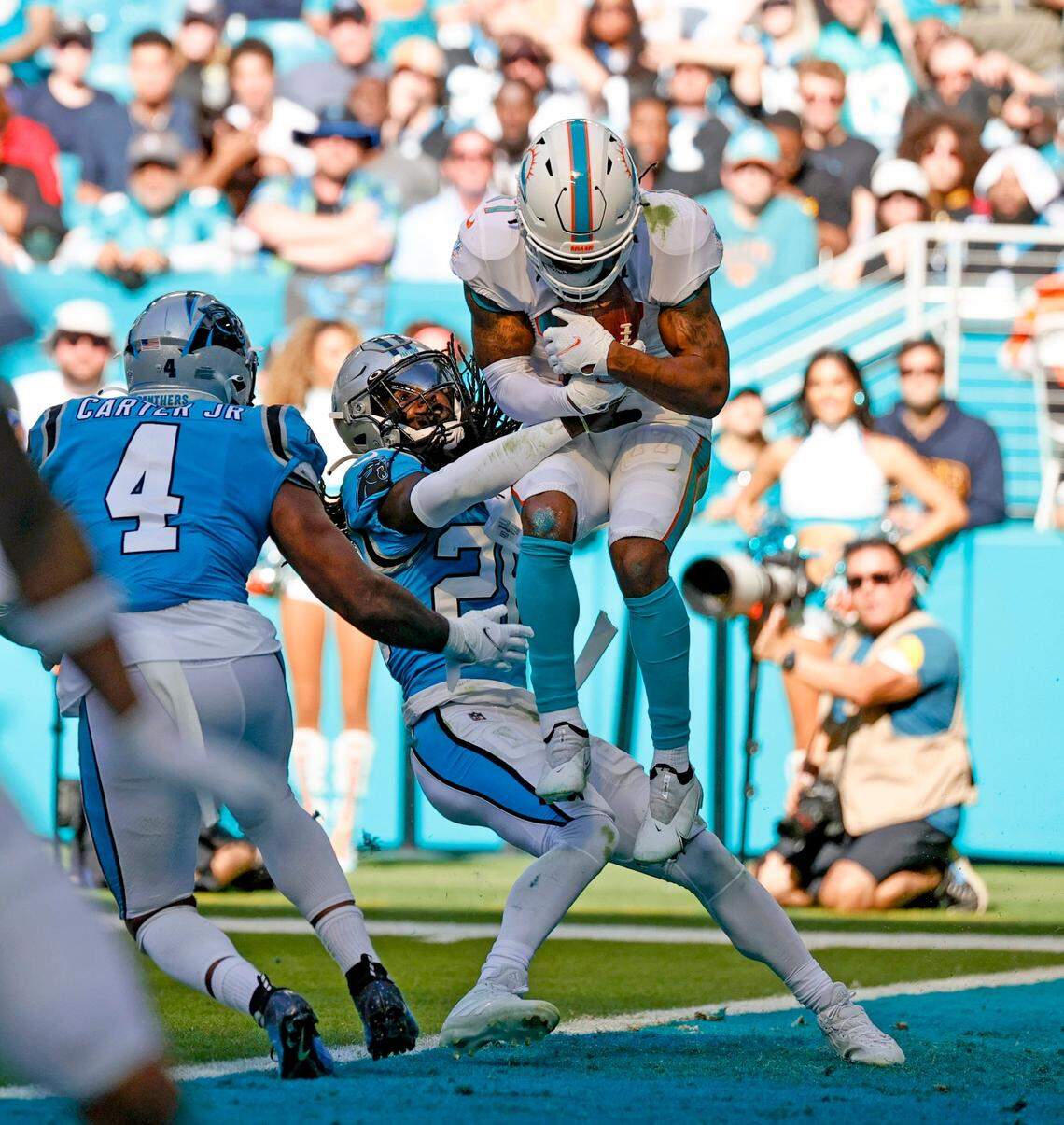 Miami Dolphins wide receiver Jaylen Waddle (17) catches a pass for a touchdown against Carolina Panthers cornerback Donte Jackson (26) and Panthers middle linebacker Jermaine Carter (4) during the second quarter of an NFL football game at Hard Rock Stadium on Sunday, November 28, 2021 in Miami Gardens, Florida.