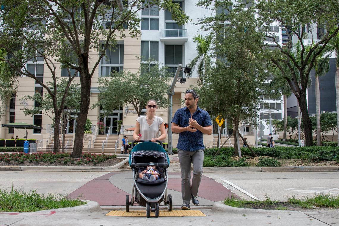 Brickell Residents Margarita and Yakov Villasmil cross the street with their baby in Miami on Monday, May 28, 2018.