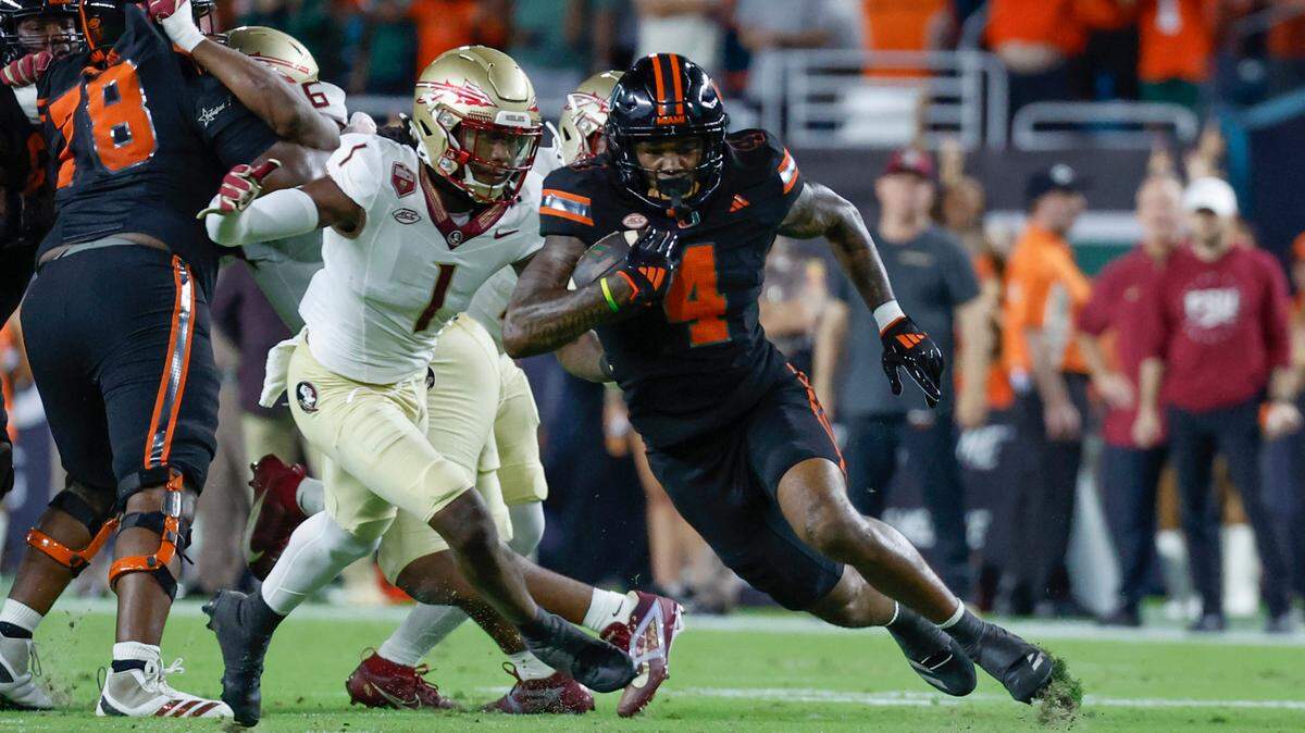 Miami Hurricanes running back Mark Fletcher Jr. (4) on a carry as Florida State Seminoles defensive back Charles Lester III (4) gives chase in the first half during an NCAA football game at Hard Rock Stadium in Miami Garden, Florida on Saturday, October 26, 2024.