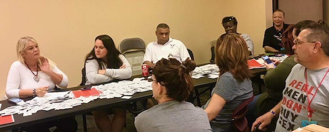 Theresa Flores, left, Joyce Dixson-Haskette, right, and a volunteer wearing a “Real Men Don’t Buy Sex” T-shirt, prepare to label soaps with sex-trafficking hotline numbers and distribute them to local hotels and motels.