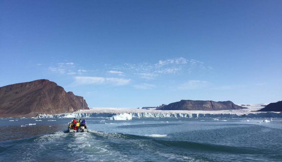 Inuit hunters and researchers on a fjord searching for narwhals in Greenland.