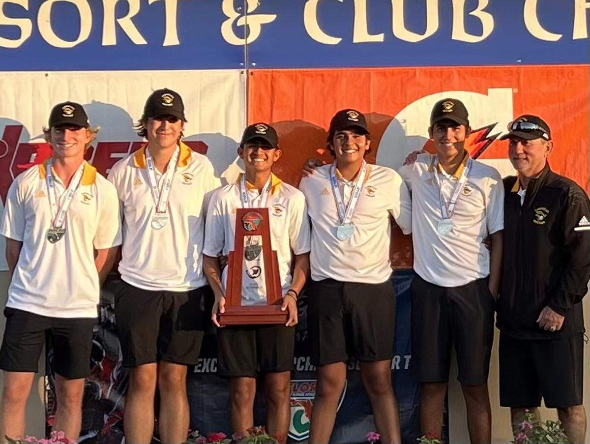 American Heritage’s boys’ golf players and coach Brandt Moser pose with their state runner-up trophy after the team placed second at the Class 2A state championship meet on Wednesday at Howey-in-the-Hills, Fla.