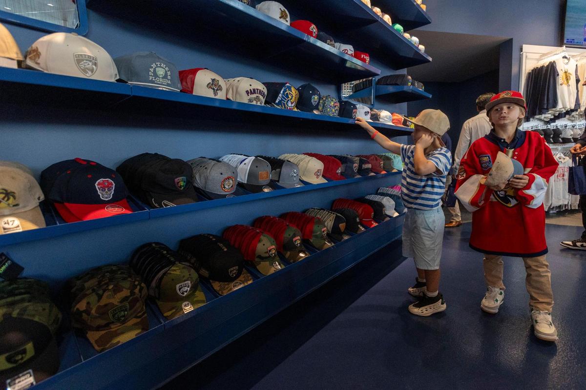Two young boys try on Panthers hats at the store located in the newly constructed Baptist Health IcePlex in Fort Lauderdale.