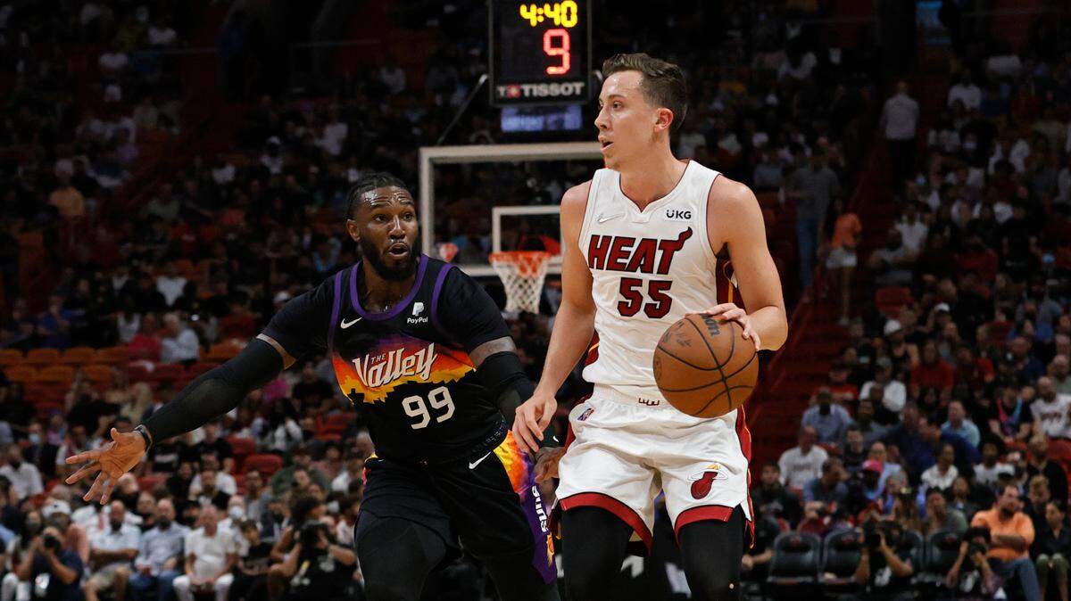 El delantero del Heat Duncan Robinson (55) lleva el balón marcado por Jae Crowder, de los Suns de Phoenix, el 9 de marzo de 2022 en el FTX Arena de Miami.