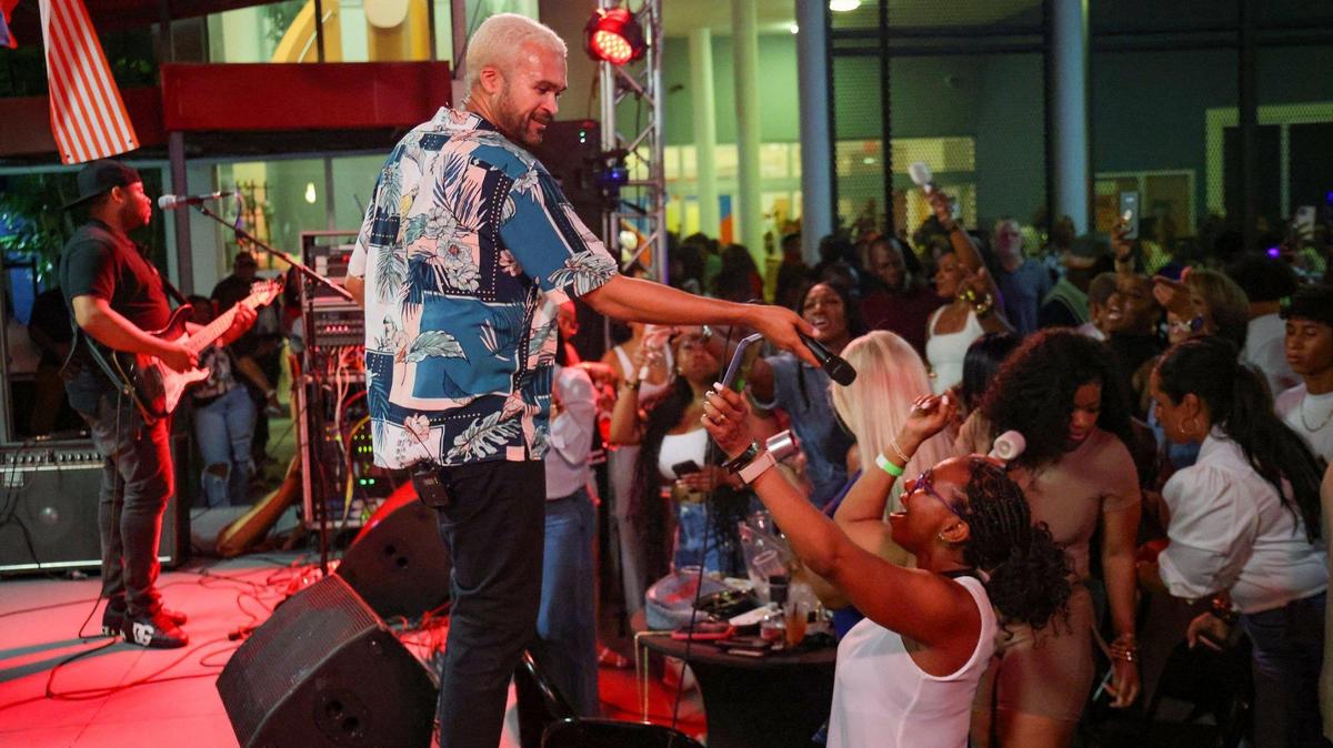 A month after igniting the crowd at Miami’s Compas Festival, Haitian konpa star Richard Cave extends his microphone to a fan as he performs with his band KAI and delivers another electrifying performance on Friday, June 20, 2025, at “Sounds of Little Haiti” in Miami, Florida.