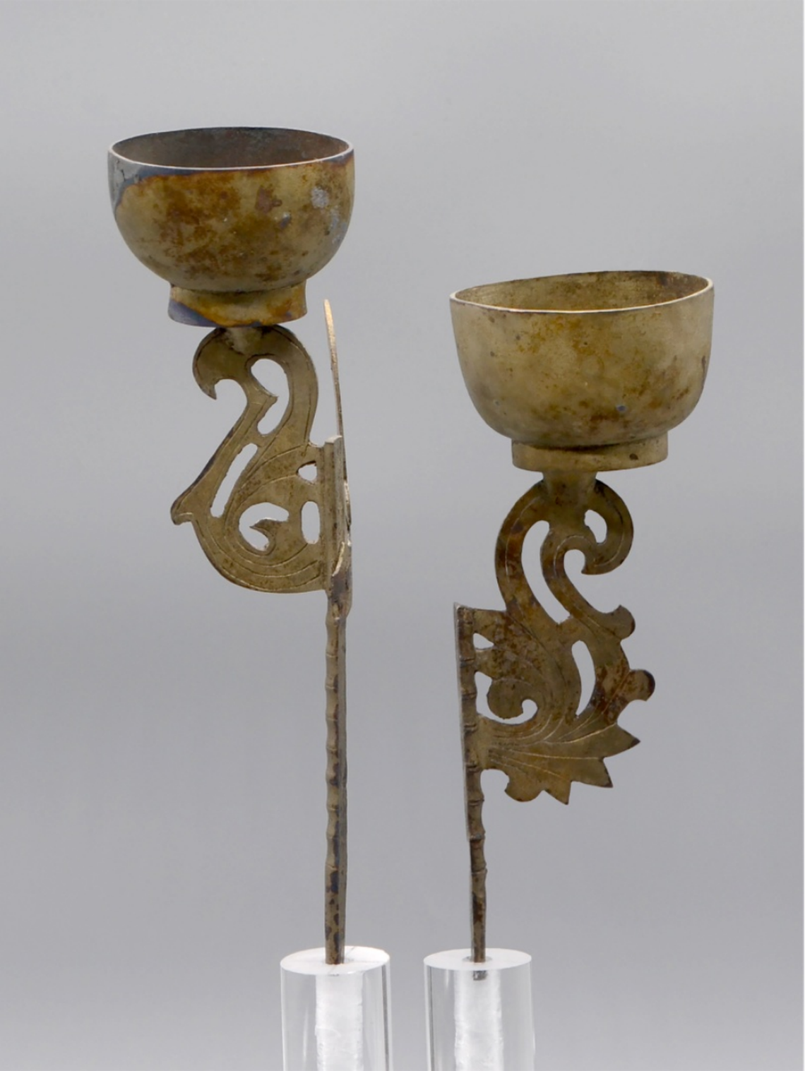 Two lamps, part of a bronze chandelier, found in a well.