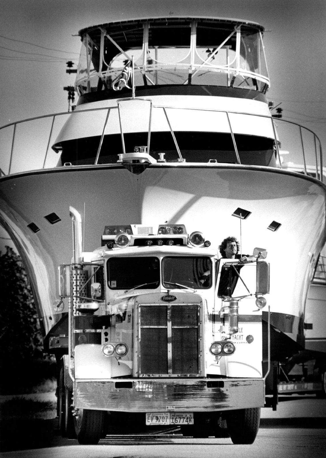 Driver Bill Joule stops to survey the situation as his semi-truck is dwarfed by his cargo, a 66-foot yacht. Joule was towing the big boat to the Intracoastal for its trip back north after the 1986 Miami boat show.