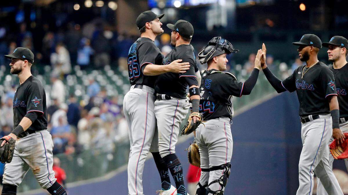 Miami Marlins relief pitcher Richard Bleier, left, chest-bumps shortstop Miguel Rojas after winning a baseball game against the Milwaukee Brewers Saturday, Oct. 1, 2022, in Milwaukee. (AP Photo/Jon Durr)
