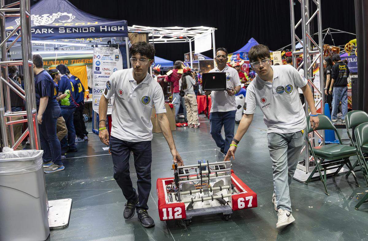 Ismail Eruz, 15, right, and Burak Pektas, 17, both members of MASAL, a team from Marmaris Sabanci High School in Muğla, Turkey, push their robot, Fairy Tale, before competing in the 2026 FIRST Robotics South Florida Regional Competition at the University of Miami’s Watsco Center on Friday, April 10, 2026, in Coral Gables, Fla. Participants from local school districts, surrounding states, and international teams are competing for an opportunity to earn a spot at the 2026 FIRST World Championship.