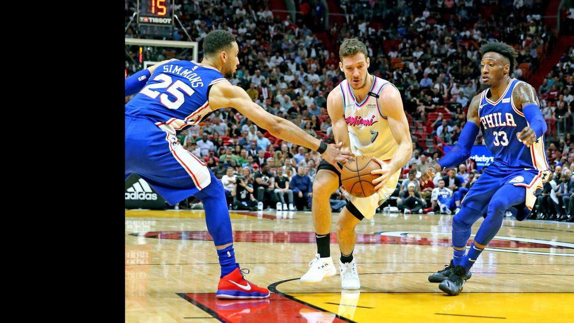 Miami Heat Goran Dragic (7) takes the ball between Philadelphia 76ers Ben Simmons (25) and Robert Covington (33) in the first quarter at the AmericanAirlines Arena in Miami, Florida, February 27, 2018.