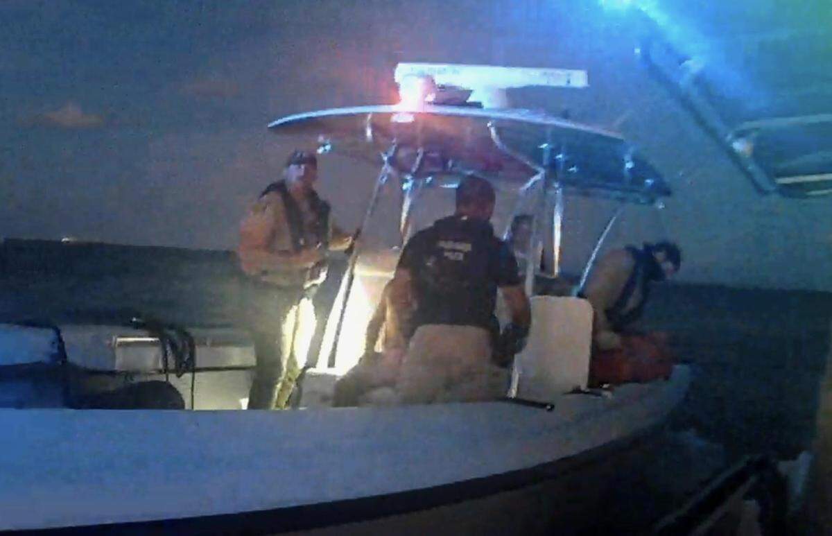 El agente de la FWC Keith Hernández mira hacia el investigador William Thompson el domingo 4 de septiembre de 2022, mientras Hernández se aleja de Thompson, cuya cámara corporal capturó las imágenes, con George Pino, el operador de un barco que se estrelló contra un marcador de milla fijo en la Bahía de Biscayne horas antes.