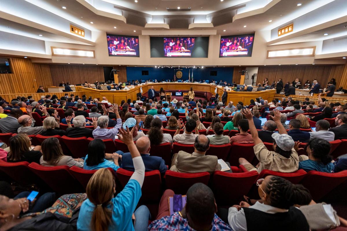 Miami, Florida, 6 de septiembre de 2023 - Personas agitan sus manos en apoyo de los oradores que expresan su oposición al parque acuático Miami Wilds durante la parte de comentarios públicos de la reunión de hoy de la Comisión del Condado Miami-Dade. Los comisionados de Miami-Dade decidieron aplazar la votación sobre si el parque acuático Miami Wilds, el proyecto con fines de lucro afuera del Zoo Miami, puede seguir adelante. Los grupos ecologistas dicen que destruirá el hábitat de murciélagos en peligro de extinción y otras especies. Los urbanizadores lo llaman un impulso al zoológico que no dañará a la naturaleza.