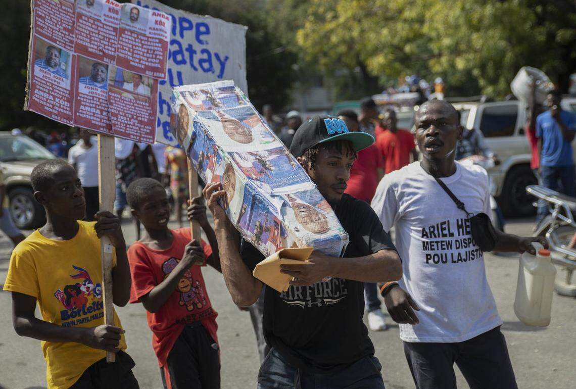 Demonstrators carry around a mock coffin as they protest for justice in connection with the assassination of late President Jovenel Moise in Port-au-Prince, Haiti, Monday, Feb. 7, 2022.