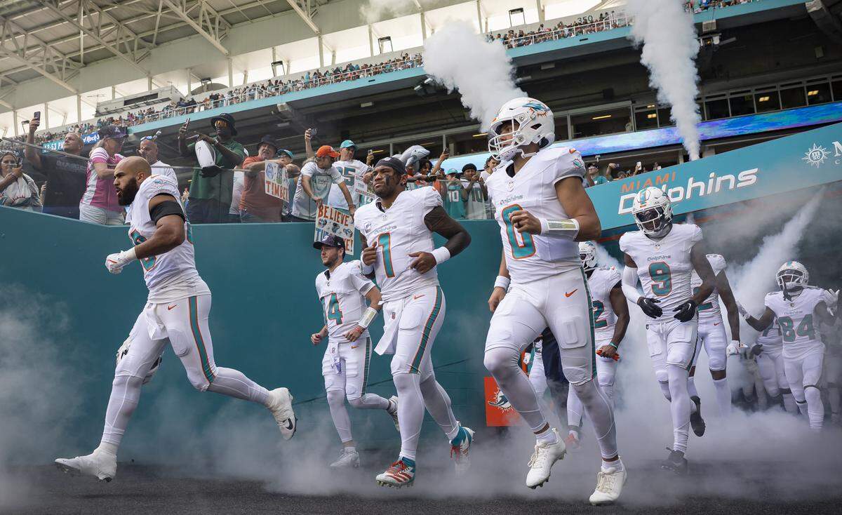 Miami Dolphins quarterback Tua Tagovailoa (1) makes his way on the field with his teammates before their NFL game against the Los Angeles Chargers at Hard Rock Stadium on Sunday, Oct. 12, 2025, in Miami Gardens, Fla.