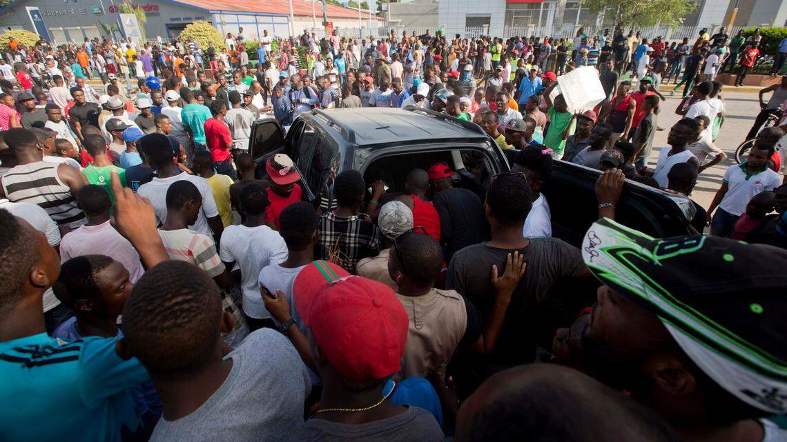 Protesters loot a car that careened out of control and hit a group of people in Port-au-Prince, Haiti, on Nov. 21, 2018.