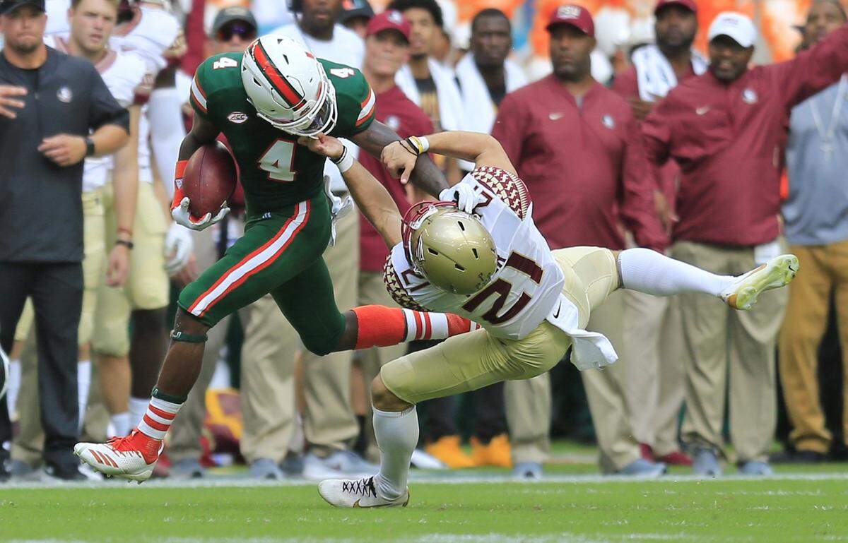 Miami Hurricanes wide receiver Jeff Thomas (4) is faced masked by Florida State Seminoles punter Logan Tyler (21) in the second quarter as the University of Miami host Florida State University at hards Rock Stadium in Miami Gardens on Saturday, October 6, 2018.