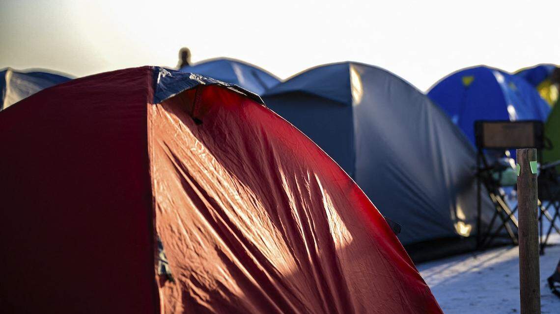 A runner prepares near tents at the campsite during the Runfire Salt Lake '25 Ultramarathon in Salt Lake, Eskil - Aksaray, Turkey on August 23, 2025. The ultramarathon is a two-day endurance race that brings together runners and outdoor enthusiasts who camp on the vast salt plain while competing in extreme desert-like conditions. (Photo by Armagan Altun / Middle East Images via AFP)