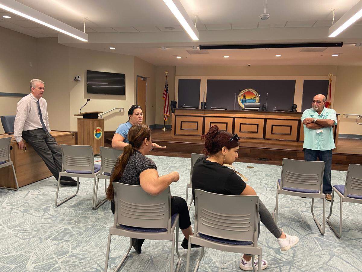 Marathon City Attorney Steven Williams listens as Karen Ortega, a Florida Keys property manager, speaks to residents of Mariner Place apartments Thursday, Feb. 24, 2022. Ortega has been advocating on behalf of the tenants ever since they were told they must leave the building because it is unsafe to live in.