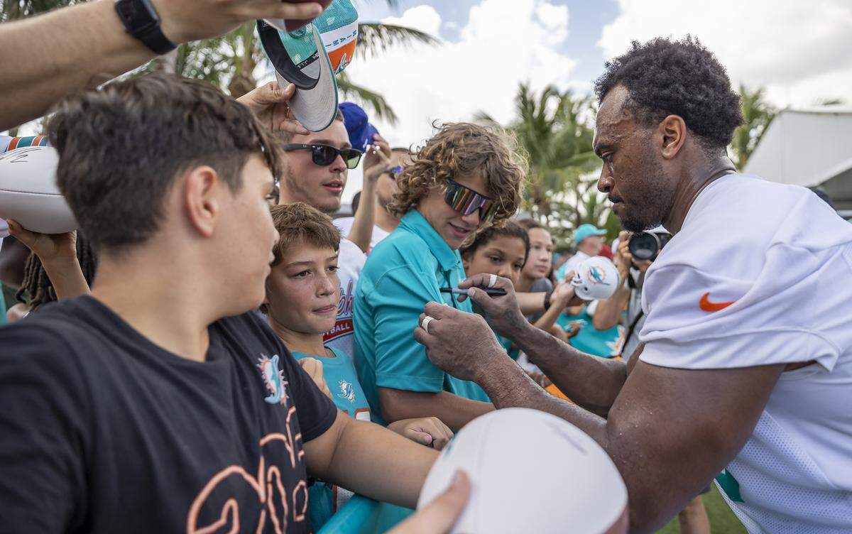 Miami Dolphins guard Austin Jackson (73) signs autographs for fans after participating in training camp at the Baptist Health Training Complex on Tuesday, July 29, 2025, in Miami Gardens, Fla.